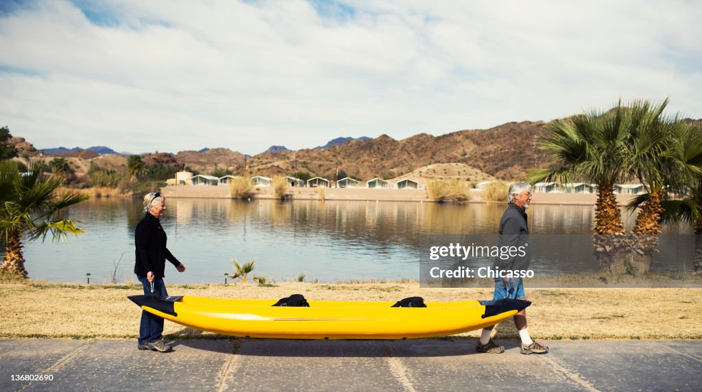 Senior Caucasian couple carrying kayak