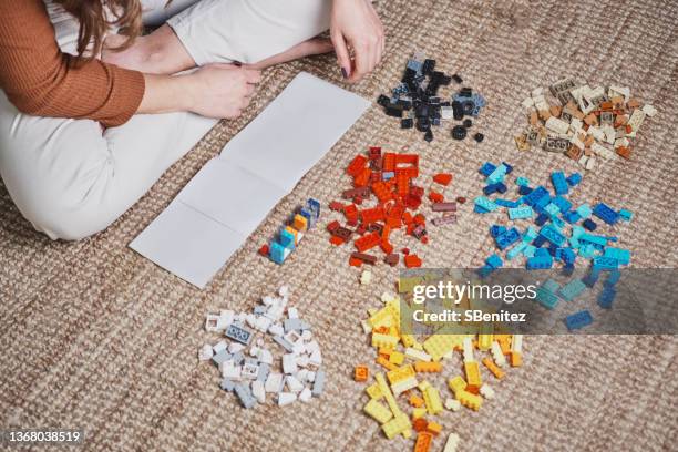 female hands playing with toys on the carpet - manual fotografías e imágenes de stock