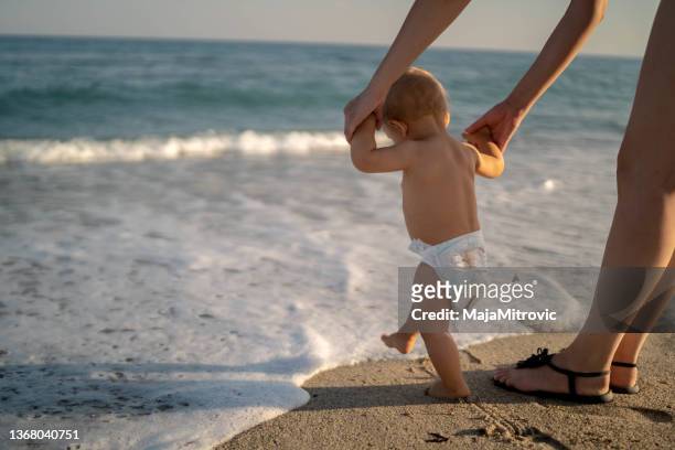 first steps at the sea beach - little feet stock pictures, royalty-free photos & images