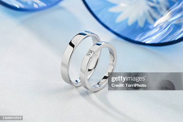 pair of stylish silver wedding rings on blue and white background - white gold stock pictures, royalty-free photos & images