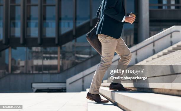 aufnahme eines geschäftsmannes, der vor einem städtischen hintergrund eine treppe hinaufgeht - steps stock-fotos und bilder