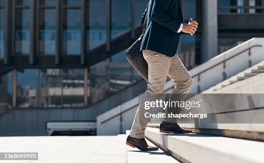 Shot of a businessman walking up a flight of stairs against an urban background Shot of a businessman walking up a flight of stairs against an urban background