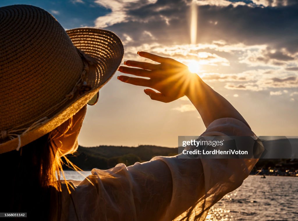 Mujer bloqueando el sol con las manos