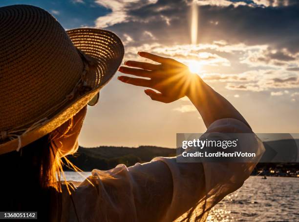 woman blocking sun with hands - blocking sun stock pictures, royalty-free photos & images