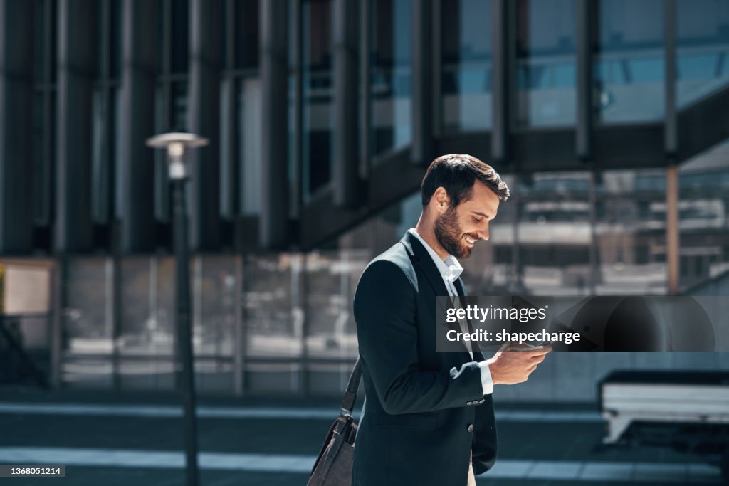 Shot of a young businessman using a smartphone against an urban background