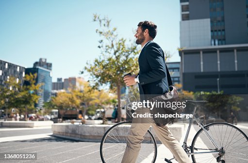 Aufnahme eines jungen Geschäftsmannes, der mit seinem Fahrrad durch die Stadt reist Aufnahme eines jungen Geschäftsmannes, der mit seinem Fahrrad durch die Stadt reist