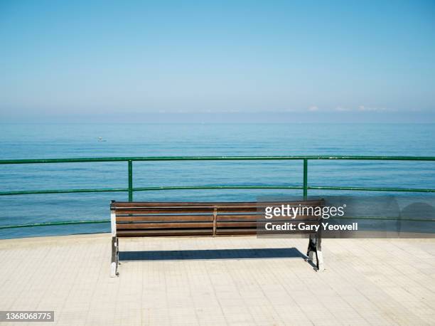 bench and sea in cefalu sicily - bench sea stock-fotos und bilder
