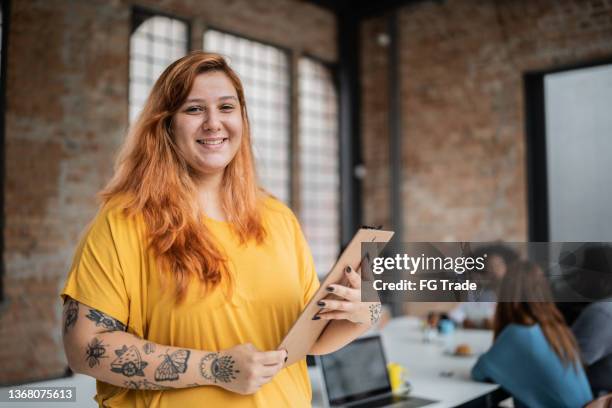 retrato de uma jovem empresária segurando uma prancheta em um escritório - nova empresa - fotografias e filmes do acervo