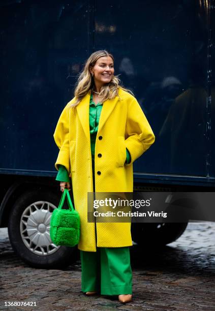 Janka Pollinai wearing yellow coat, green bag, wide leg pants seen outside Iso.Poetism by Tobias Birk during Copenhagen Fashion Week Autumn/Winter...