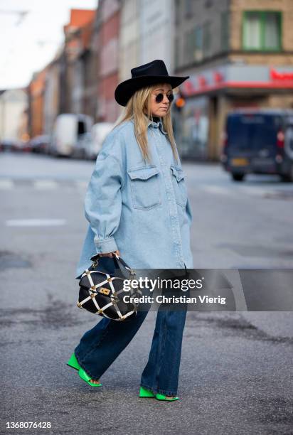 Joicy Muniz is seen wearing Hat: The Attico, Sunglasses: Vintage, Denim Jacket: The Attico, wide leg Jeans: Lois, Bag: Valentino, Shoes: The Attico...