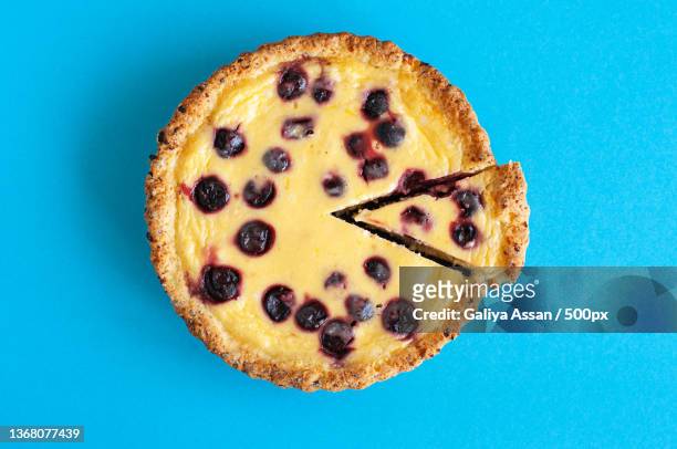 sliced ricotta cheese pie with cherries on a blue background - pie stock-fotos und bilder