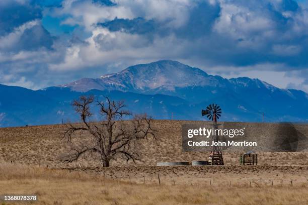 antiguo molino de viento con pikes peak al fondo - front range mountain range fotografías e imágenes de stock