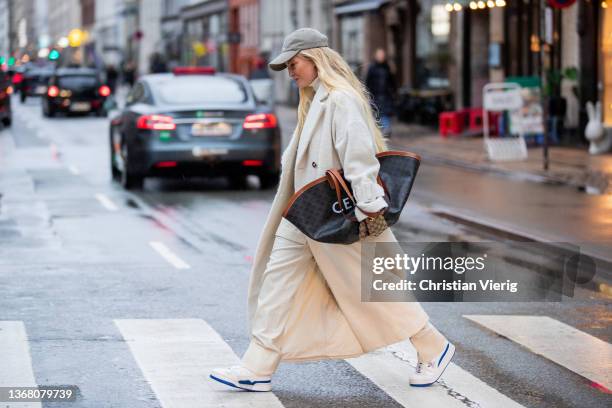 Nathalie Helgerud seen wearing cape, creme white coat, Celine bag, Gucci gloves, pants, sneaker outside Lovechild 1979 during Copenhagen Fashion Week...