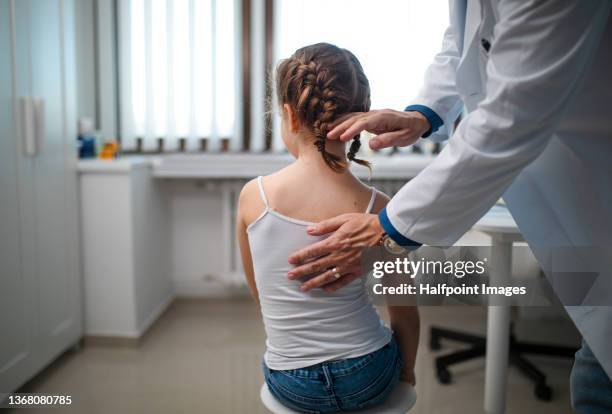 pediatrician doing development medical exam with little girl, checking posture. - scoliosis - fotografias e filmes do acervo