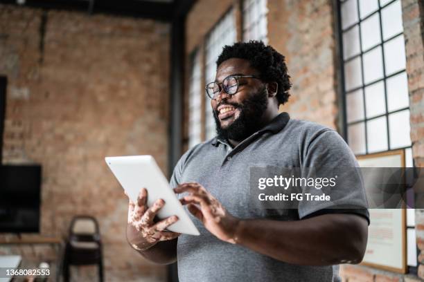 business man using digital tablet in an office - plus size model stockfoto's en -beelden