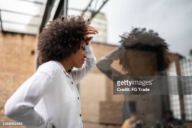 worried business woman leaning head on a window - inconveniência imagens e fotografias de stock