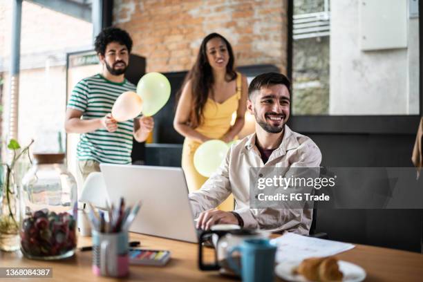 team celebrating business man birthday in the office - employee anniversary stock pictures, royalty-free photos & images