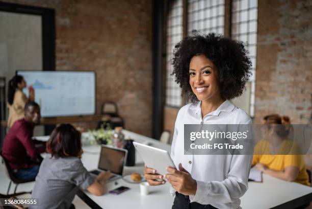 portrait of a businesswoman using digital tablet in a board room - management structure stockfoto's en -beelden