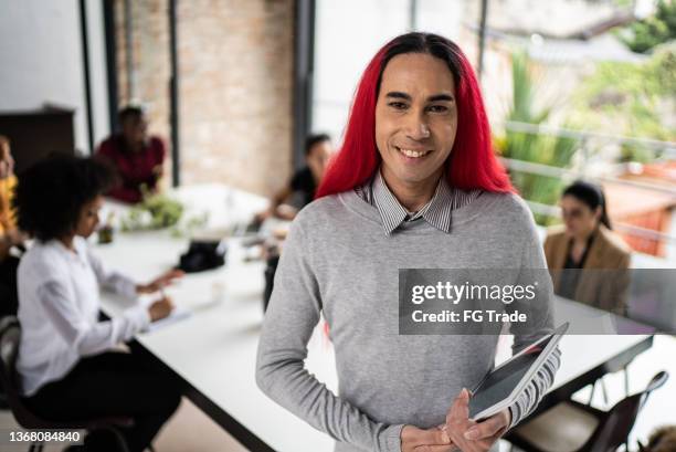 portrait of a mature man holding a digital tablet in the office - androgynous professional stock pictures, royalty-free photos & images