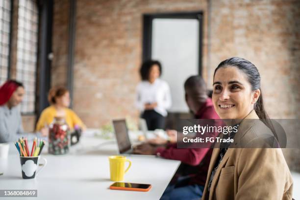 visually impaired mid adult woman in a meeting in the office - blind woman stock pictures, royalty-free photos & images