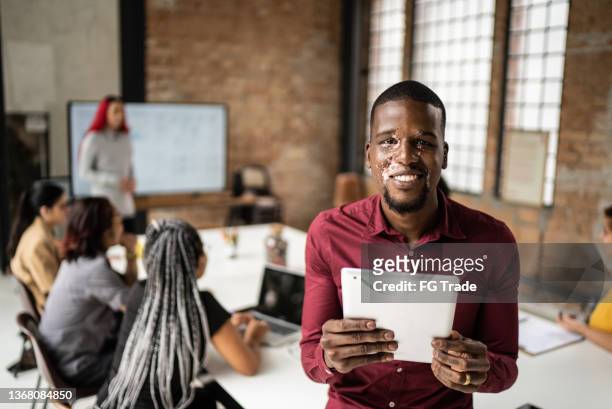 portrait of a mid adult man holding a digital tablet in the office - creative director stock pictures, royalty-free photos & images