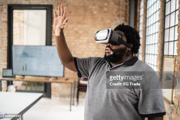 mid adult man using a virtual reality glasses in the office - virtual seminar stock pictures, royalty-free photos & images