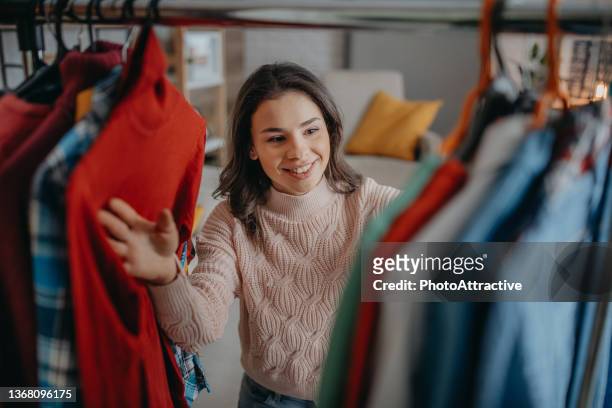 young woman choosing clothes - clothes wardrobe stockfoto's en -beelden