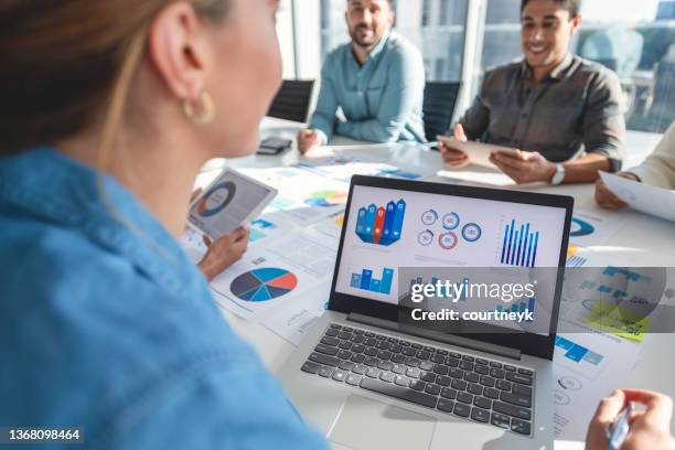 multi racial group of people working with paperwork on a board room table at a business presentation or seminar. - market research stock pictures, royalty-free photos & images