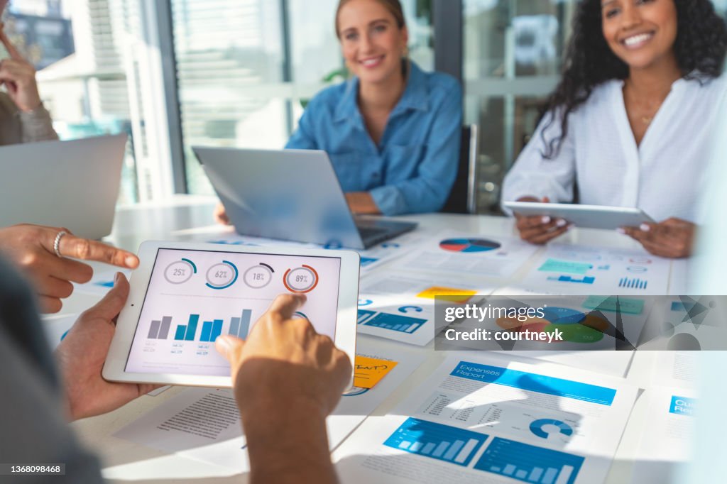 Group of people meeting with technology and paperwork
