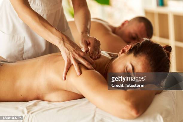 couple having a relaxing spa session - massage couple stock pictures, royalty-free photos & images