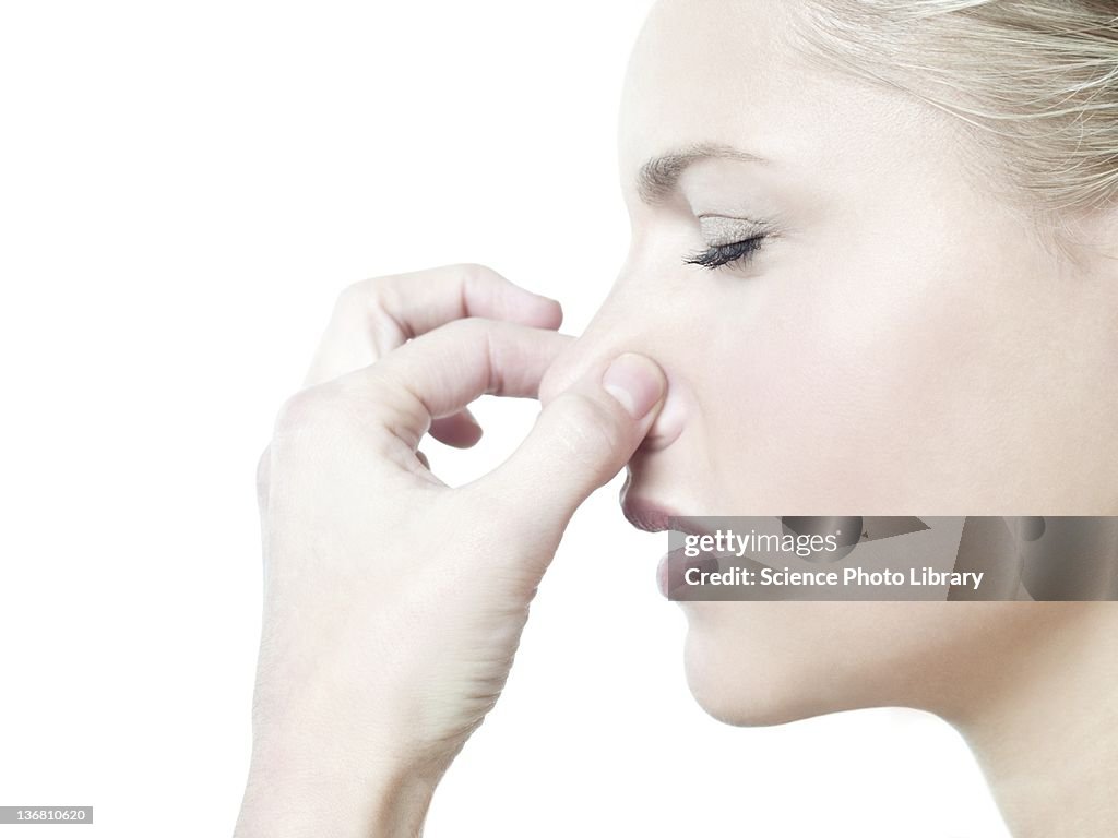 Woman holding her nose