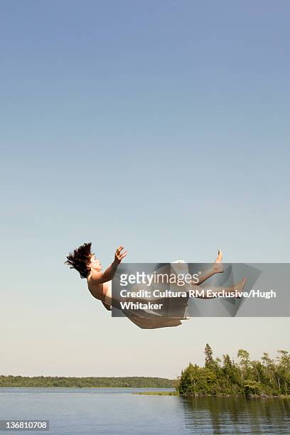 woman in dress jumping into lake - person falling mid air stock pictures, royalty-free photos & images
