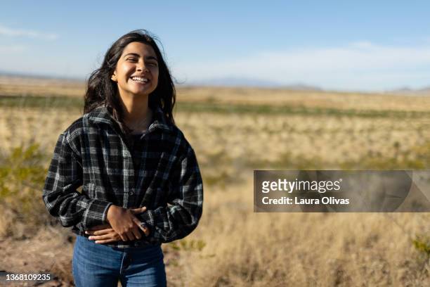 young teenage girl laughing in open field - el paso texas stockfoto's en -beelden