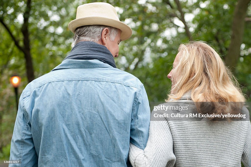 Older couple walking together in park