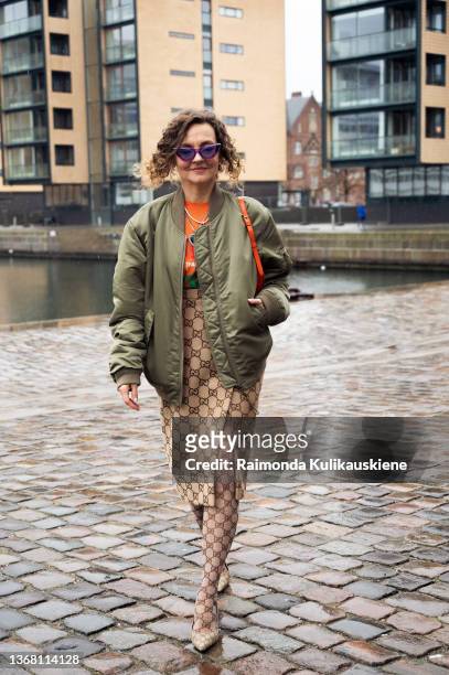 Renia Jaz wearing Gucci tights, and skirt, Balenciaga shoes, army green Celine jacket and orange bag outside Gestuz show in Copenhagen fashion week...