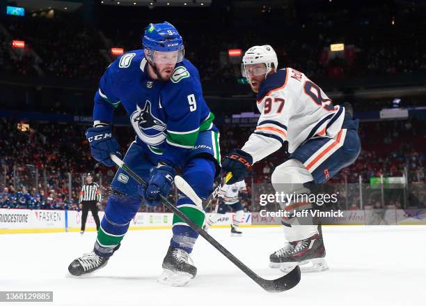 Connor McDavid of the Edmonton Oilers checks J.T. Miller of the Vancouver Canucks during their NHL game against at Rogers Arena January 25, 2022 in...