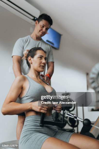 personal trainer accompanying athlete in rowing training - personalized medicine stock pictures, royalty-free photos & images