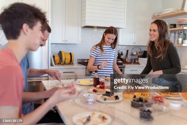 glückliche familie essen frühstück - bruder schwester kochen stock-fotos und bilder