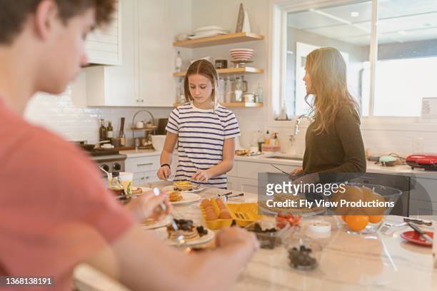 family enjoying breakfast together - boy kitchen stockfoto's en -beelden