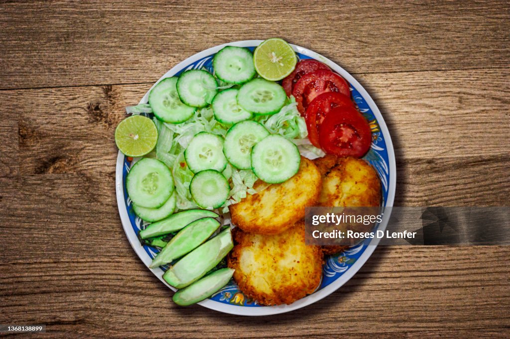 Tortas de papa con ensalada, Potato cakes, with cucumber, avocado, lettuce and tomato salad, typical Mexican food