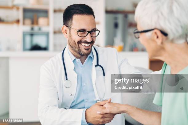 smiling doctor with senior patient - arts patient stockfoto's en -beelden
