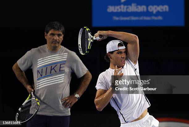 Rafael Nadal of Spain plays a forehand as he is watched by Toni Nadal, his uncle and coach during practice ahead of the 2012 Australian Open at Rod...