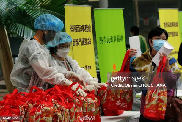 Personnel médical offrant des cadeaux pour le nouvel an chinois aux résidents d'un immeuble en fin de confinement dans le quartier de Kwai Chung le...