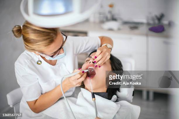 dentist removing dental calculus. - dental calculus stock pictures, royalty-free photos & images