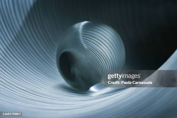 glass sphere in striped metal tube - modern quantum mechanics stock pictures, royalty-free photos & images