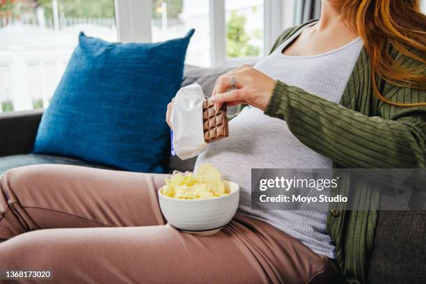 shot of an expecting mother enjoying some snacks during the day - family eating potato chips stock pictures, royalty-free photos & images