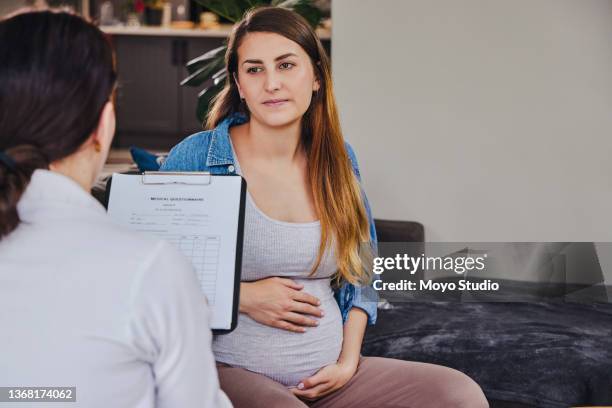 shot of a gynecologist checking in on one of her pregnant patients - human body part stock pictures, royalty-free photos & images
