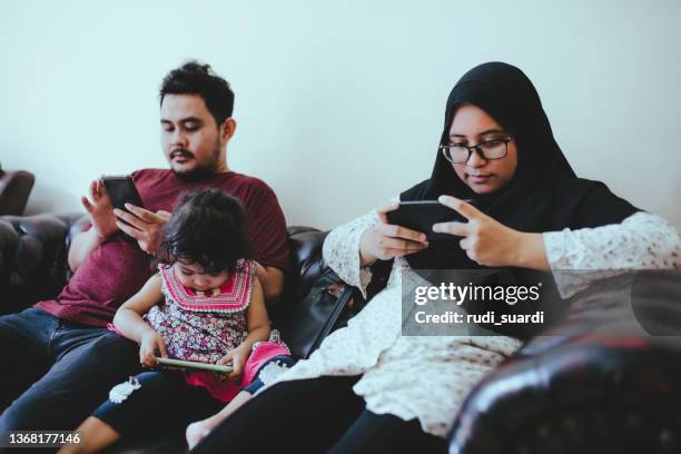 family using various technologies in living room at home - rise from the grave stock pictures, royalty-free photos & images