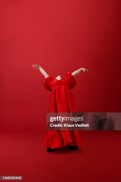 young woman with head back against red background - women in long dress stock pictures, royalty-free photos & images