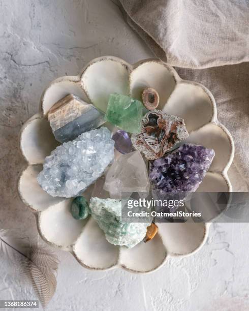 overhead view of assorted crystals in a scalloped dish - quartz stockfoto's en -beelden